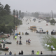 People walk down a flooded street as they evacuate their homes after the area was flooded during Hurricane Harvey on August 28, 2017 in Houston, Texas.
